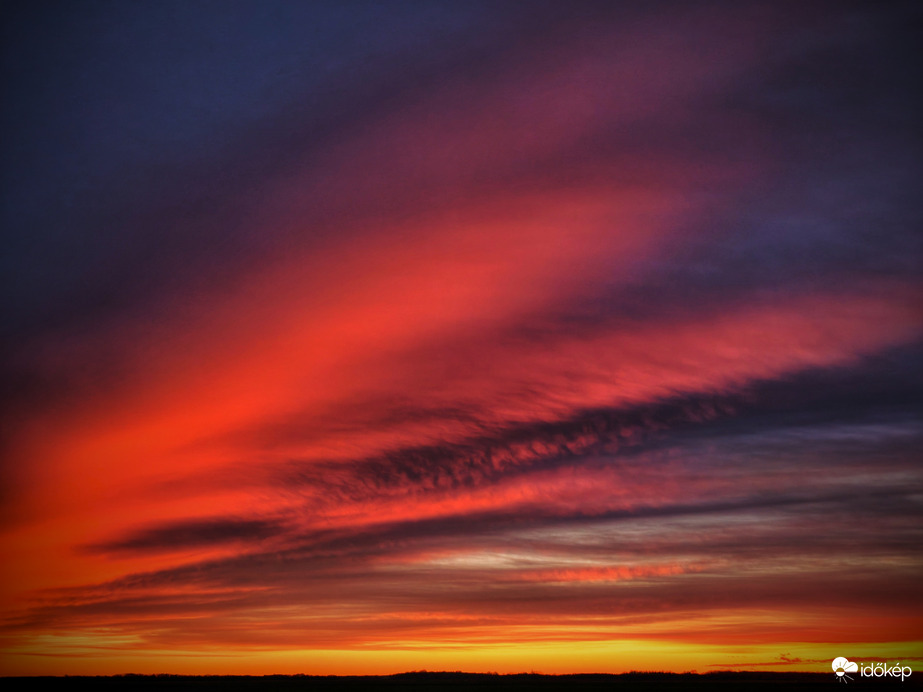 Felhők vonulatai a szilveszteri napnyugta idején
