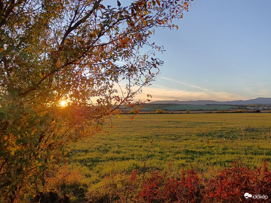 Naplemente a őszi lomb ölelésében