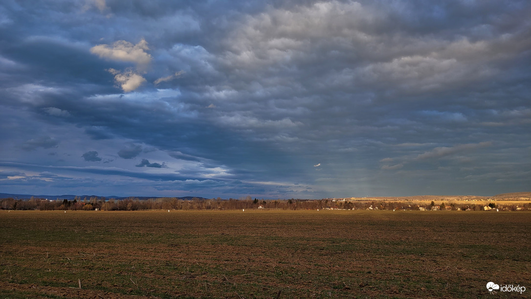 Mélykék és kékesszürke felhő közt napsugarak
